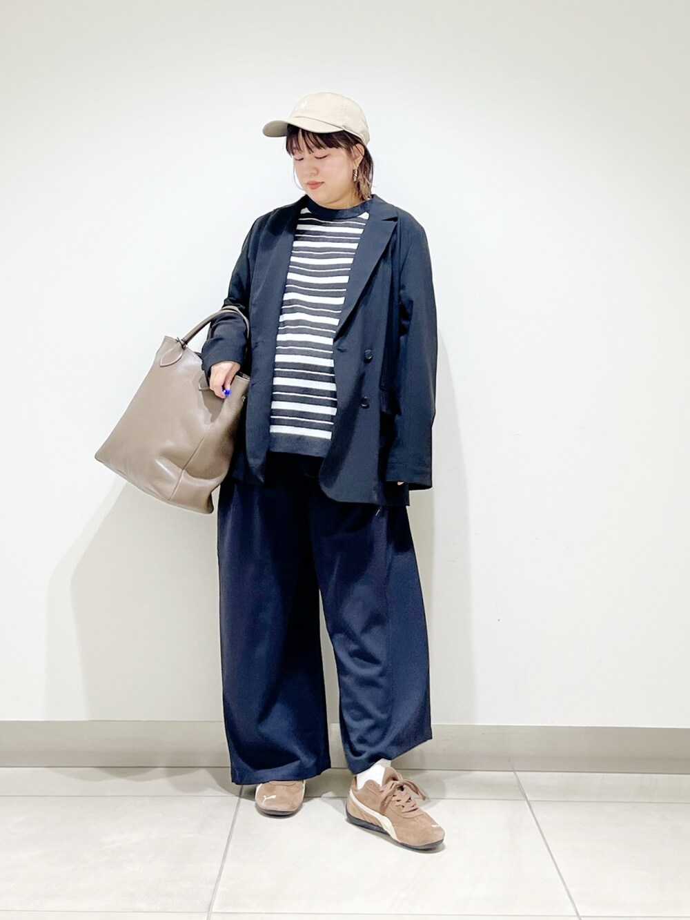 ブラック系のその他アウター、グレー系のニット/セーター、グレー系のトートバッグを着用したレディースの秋コーディネートの7枚目の写真