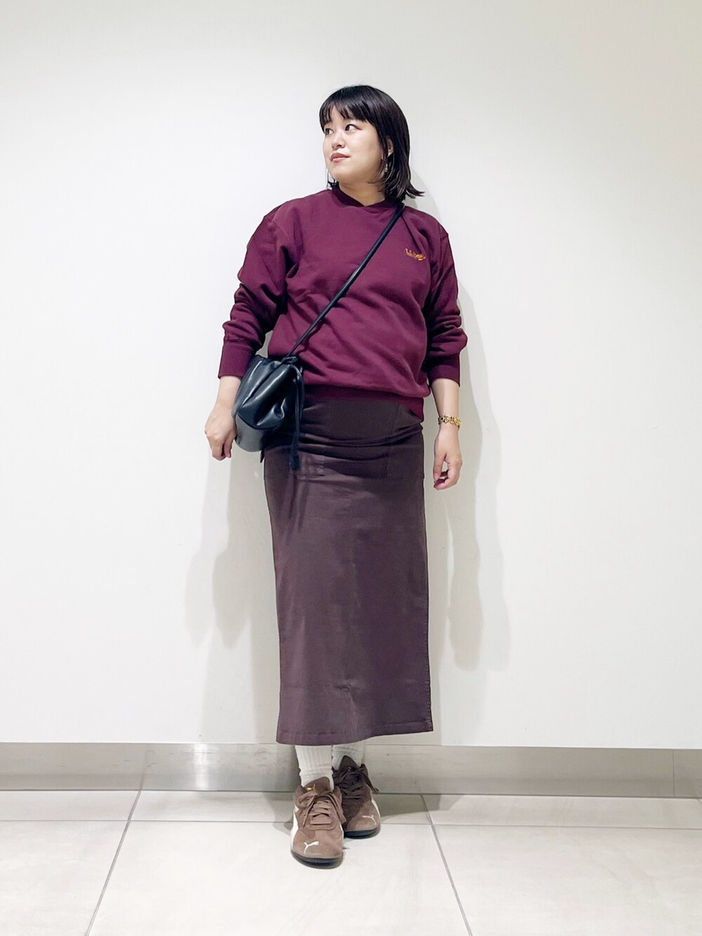 ブラウン系のスウェット、ブラウン系のスカート、ブラック系のスニーカーを着用したレディースの秋コーディネートの4枚目の写真