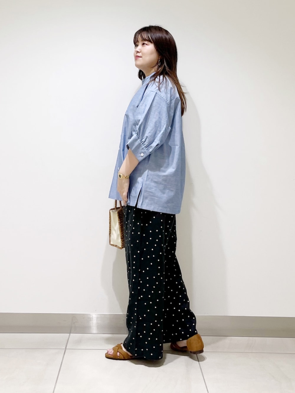 ブルー系のシャツ/ブラウス、ブラック系のその他パンツ、ベージュ系のハンドバッグを着用したレディースの夏コーディネートの5枚目の写真
