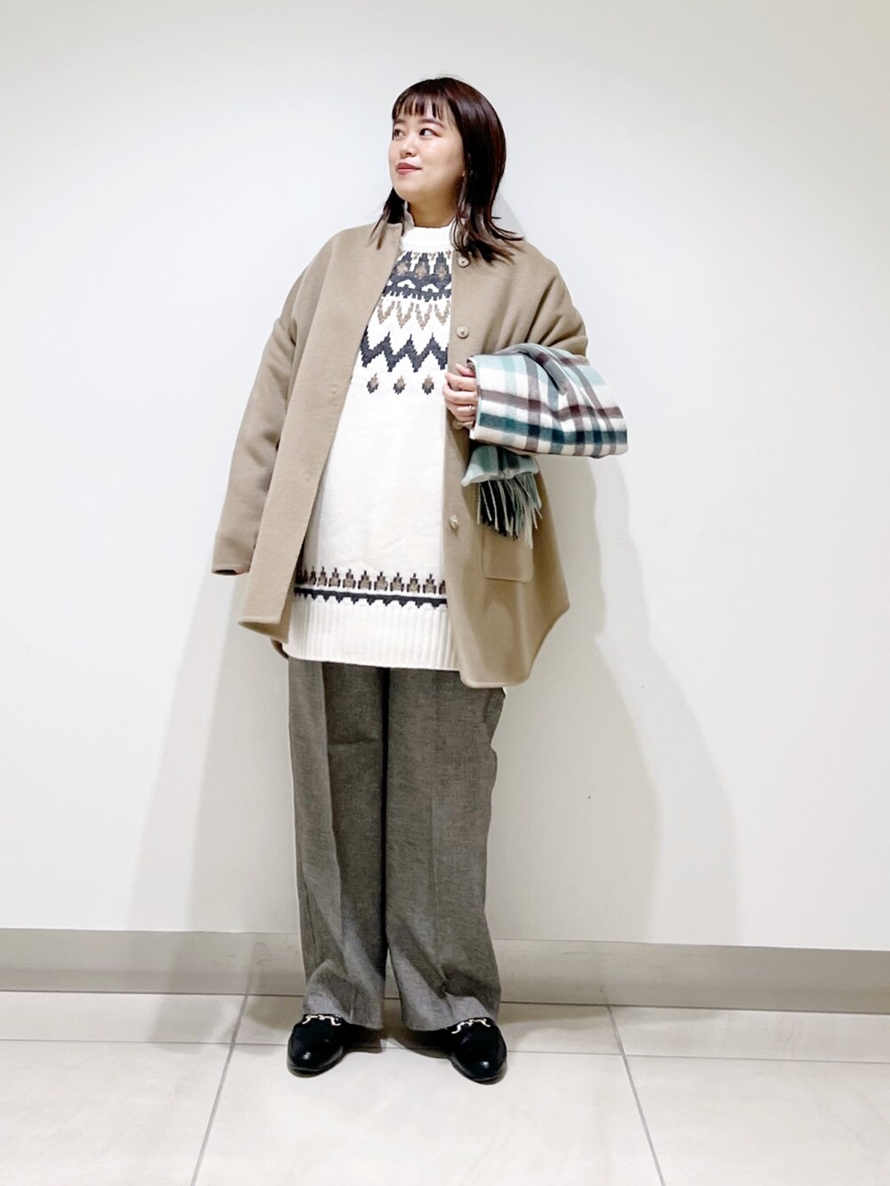 ベージュ系のノーカラージャケット、ホワイト系のニット/セーター、グレー系のその他パンツを着用したレディースの秋コーディネートの2枚目の写真