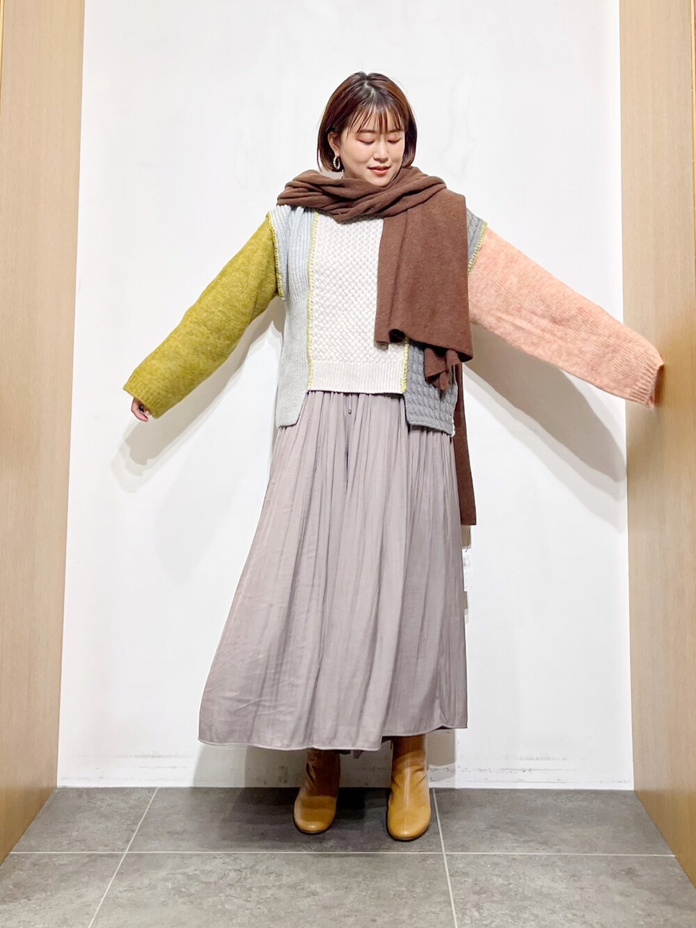 イエロー系のニット/セーター、グレー系のその他パンツ、イエロー系のブーツを着用したレディースの秋コーディネートの4枚目の写真