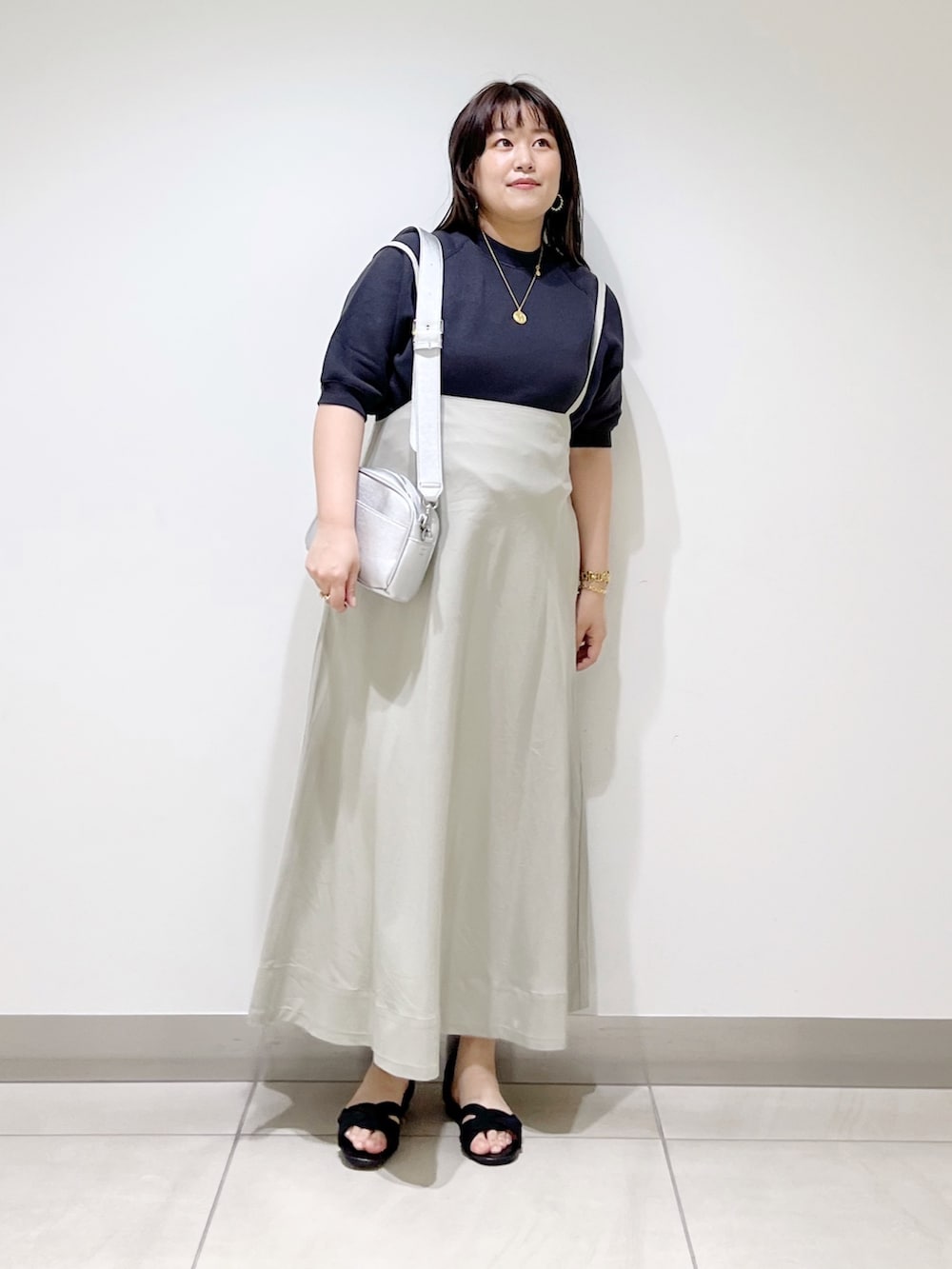 グレー系のTシャツ/カットソー、ベージュ系のスカート、シルバー系のショルダーバッグを着用したレディースの春コーディネートの3枚目の写真