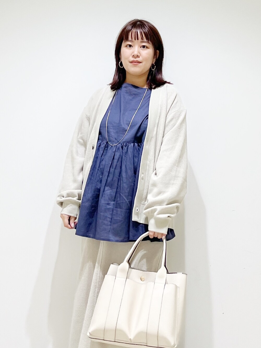 ブルー系のシャツ/ブラウス、ベージュ系のカーディガン/ボレロ、ベージュ系のスカートを着用したレディースの夏コーディネートの3枚目の写真