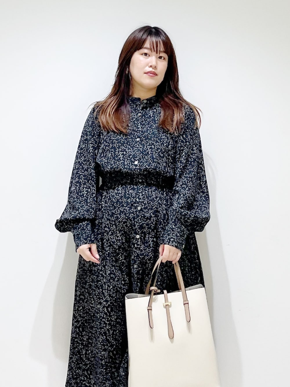 ブラック系のワンピース、ホワイト系のトートバッグ、グレー系のスニーカーを着用したレディースの夏コーディネートの5枚目の写真