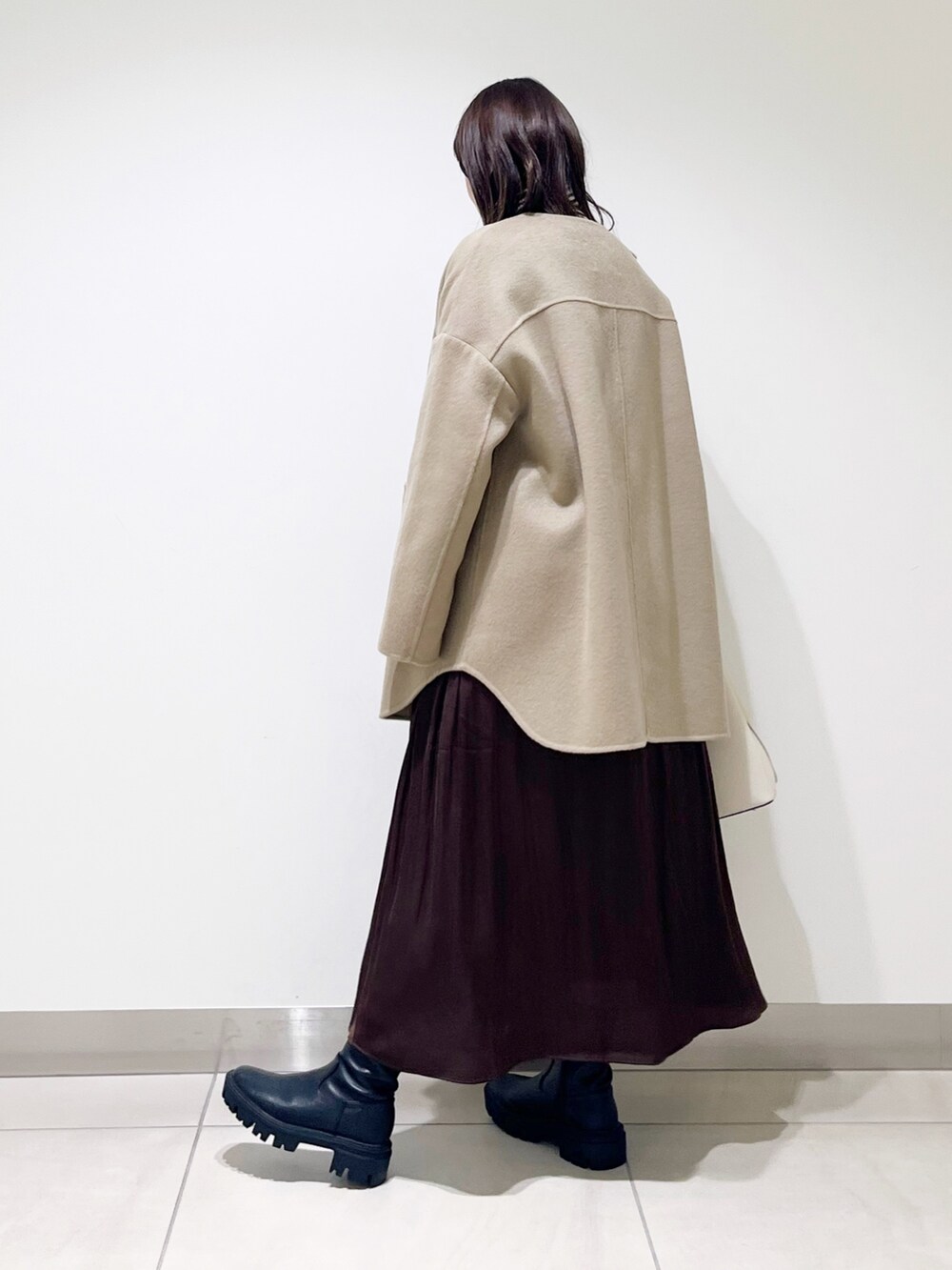 ベージュ系のノーカラージャケット、ブラウン系のニット/セーター、ブラウン系のスカートを着用したレディースの秋コーディネートの5枚目の写真