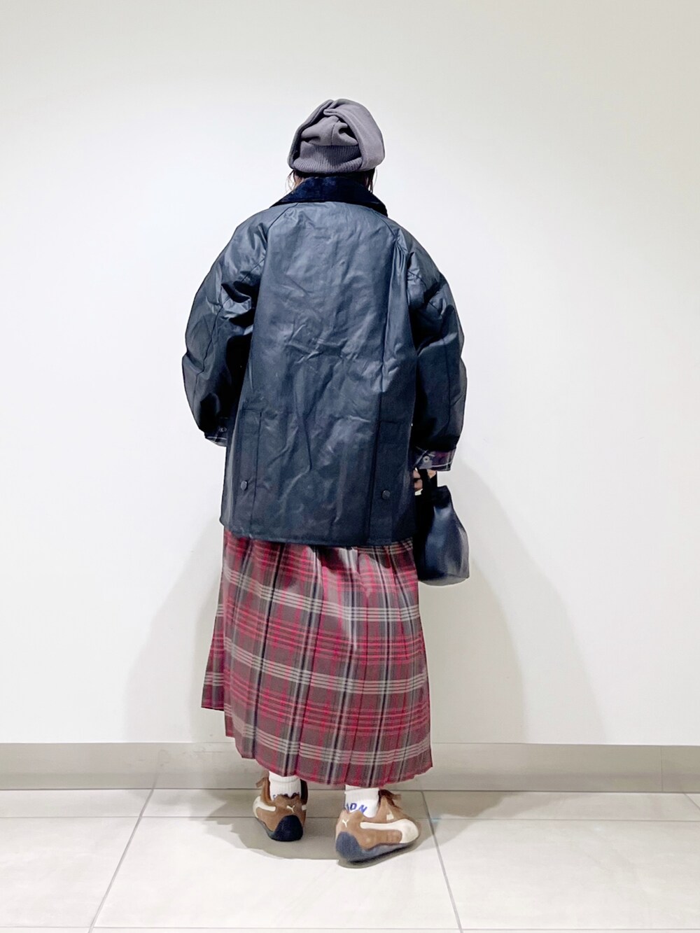 ブラック系のテーラードジャケット、グレー系のTシャツ/カットソー、ブラウン系のスカートを着用したレディースの秋コーディネートの7枚目の写真