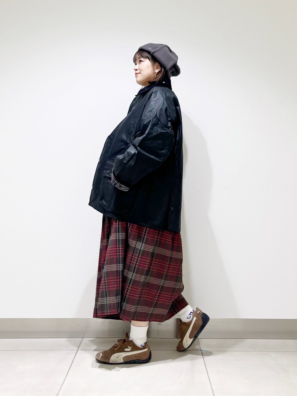 ブラック系のテーラードジャケット、グレー系のTシャツ/カットソー、ブラウン系のスカートを着用したレディースの秋コーディネートの6枚目の写真