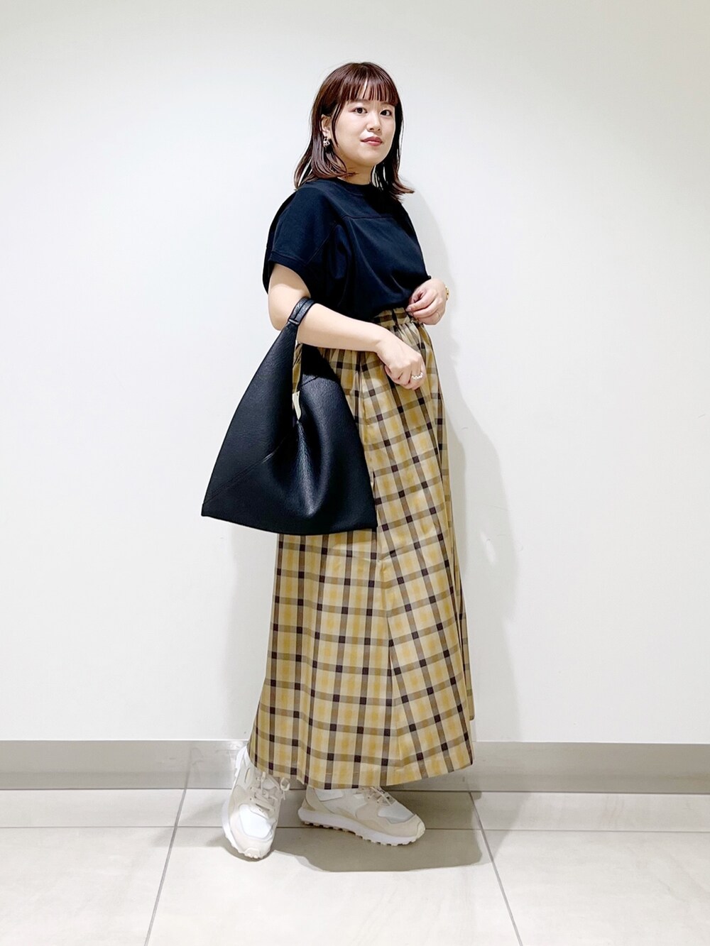 ホワイト系のスニーカー、ブラック系のTシャツ/カットソー、ブラック系のトートバッグを着用したレディースの秋コーディネートの10枚目の写真