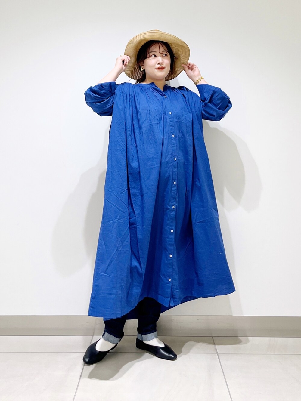 ブルー系のワンピース、ブルー系のデニムパンツ、ブラック系のバレエシューズを着用したレディースの春コーディネートの2枚目の写真