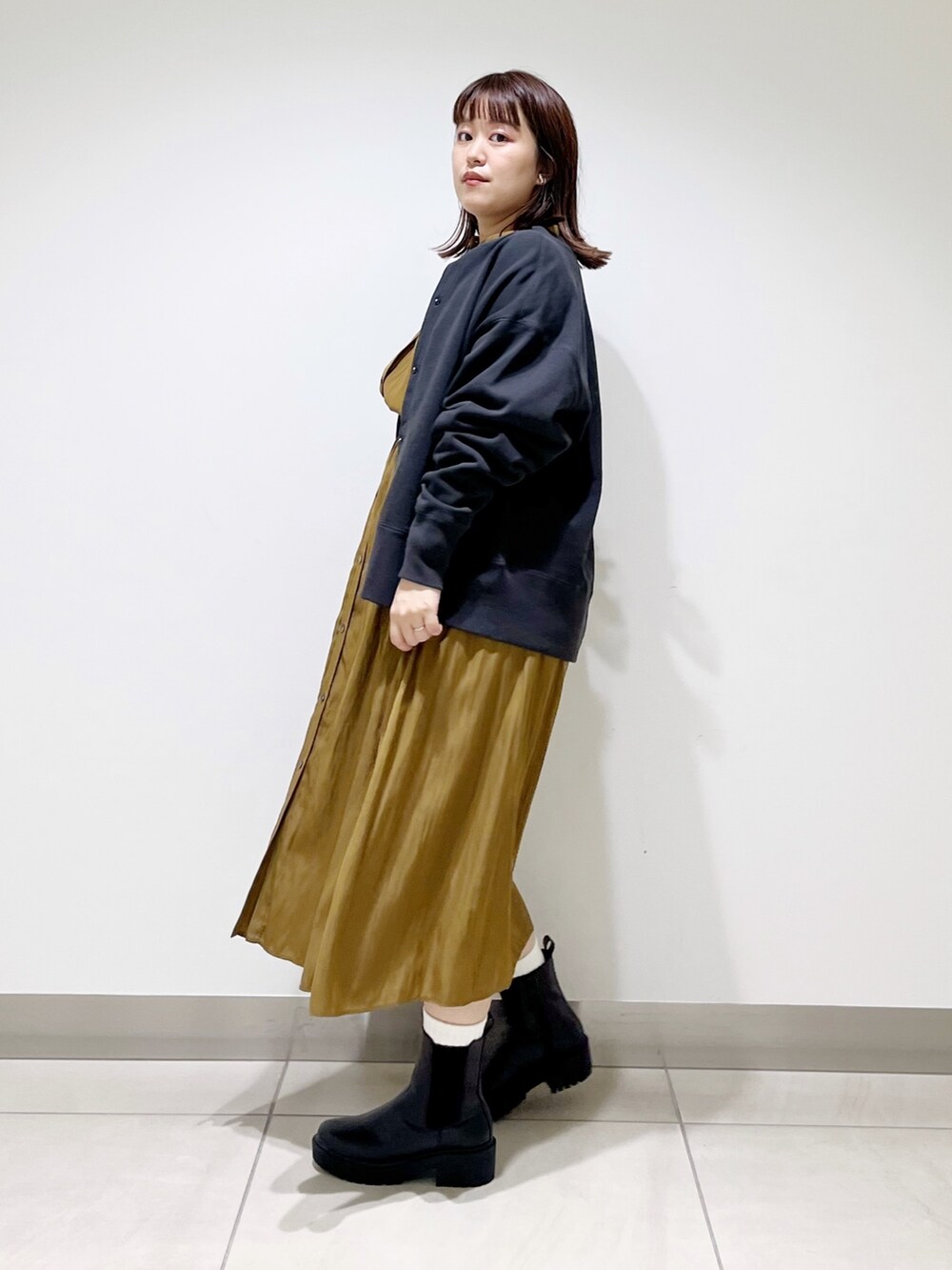 グリーン系のワンピース、その他のトップス、ブラック系のブーツを着用したレディースの秋コーディネートの7枚目の写真