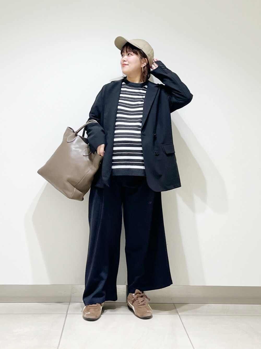 ブラック系のその他アウター、グレー系のニット/セーター、グレー系のトートバッグを着用したレディースの秋コーディネートの6枚目の写真