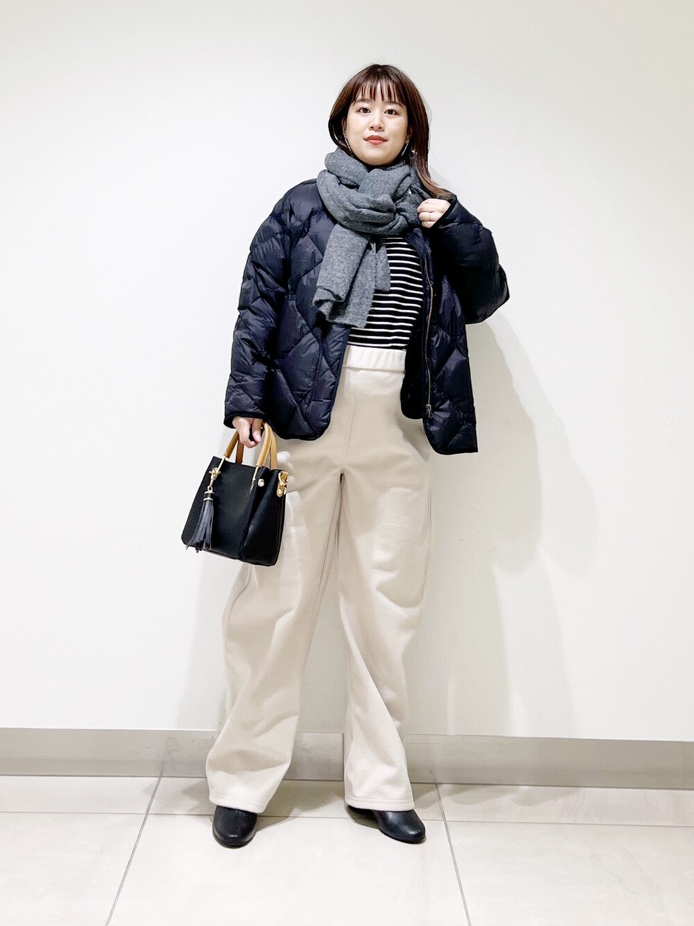 ブラック系のTシャツ/カットソー、ブラック系のダウンジャケット/コート、ブラック系のトートバッグを着用したレディースの秋コーディネートの4枚目の写真