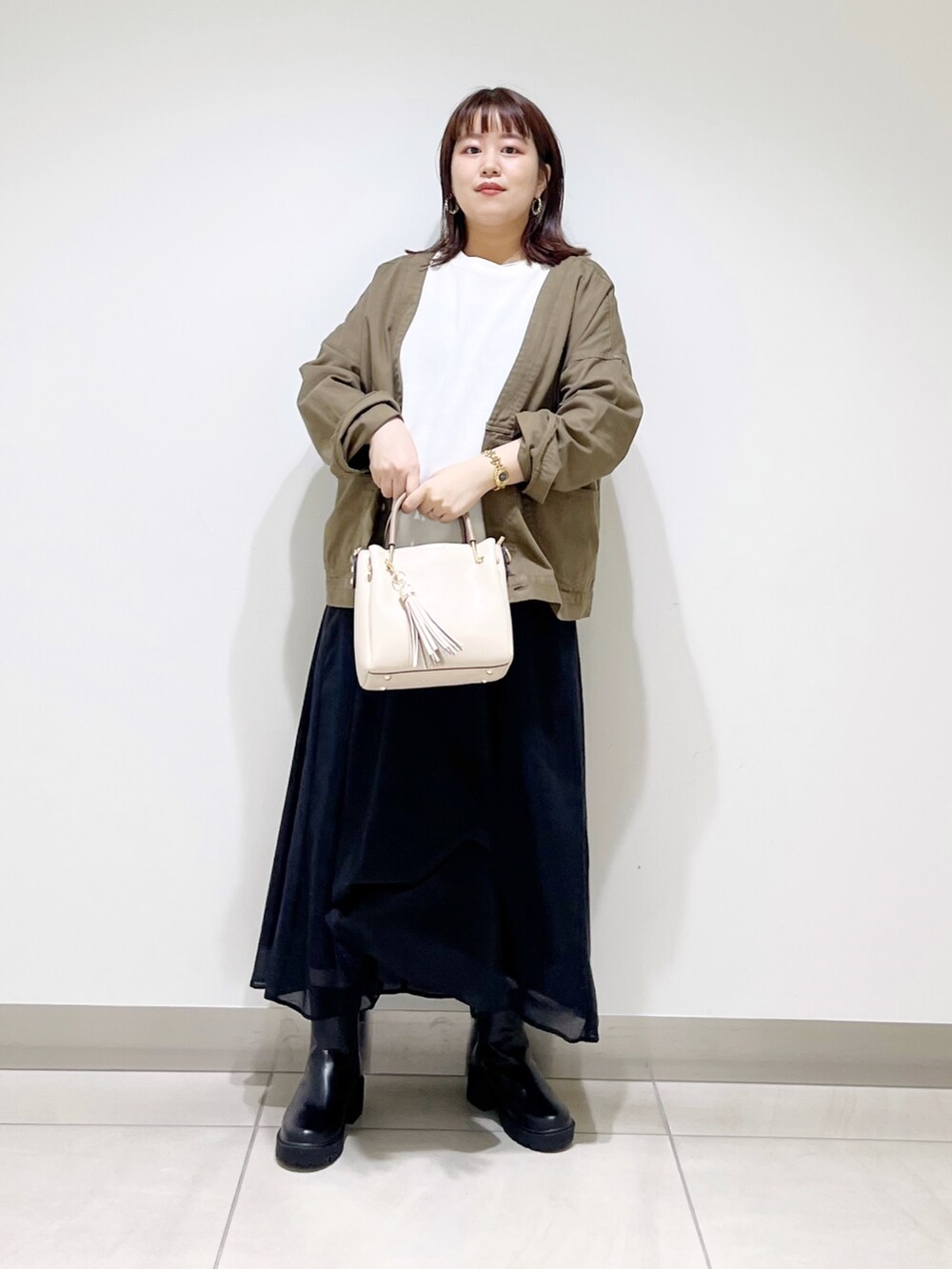 ホワイト系のTシャツ/カットソー、グリーン系のジャケット/アウター、ブラック系のスカートを着用したレディースの夏コーディネートの3枚目の写真