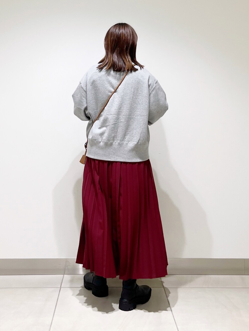 ホワイト系のトップス、グレー系のトップス、その他のスカートを着用したレディースの秋コーディネートの4枚目の写真