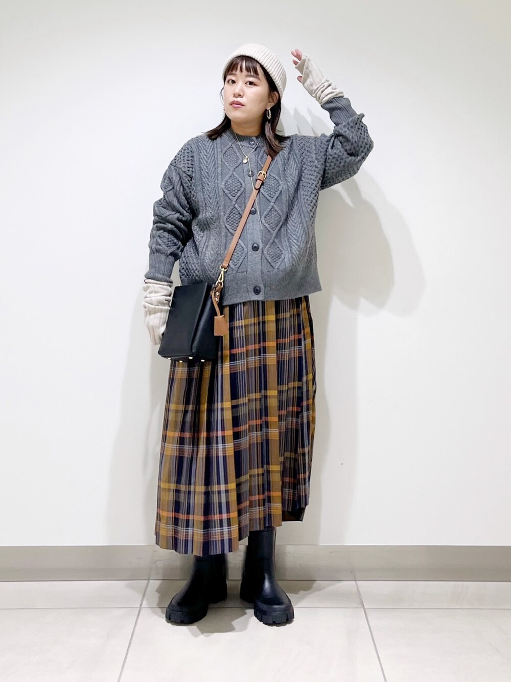 グレー系のカーディガン/ボレロ、ブルー系のスカート、ブラック系のショルダーバッグを着用したレディースの冬コーディネートの2枚目の写真