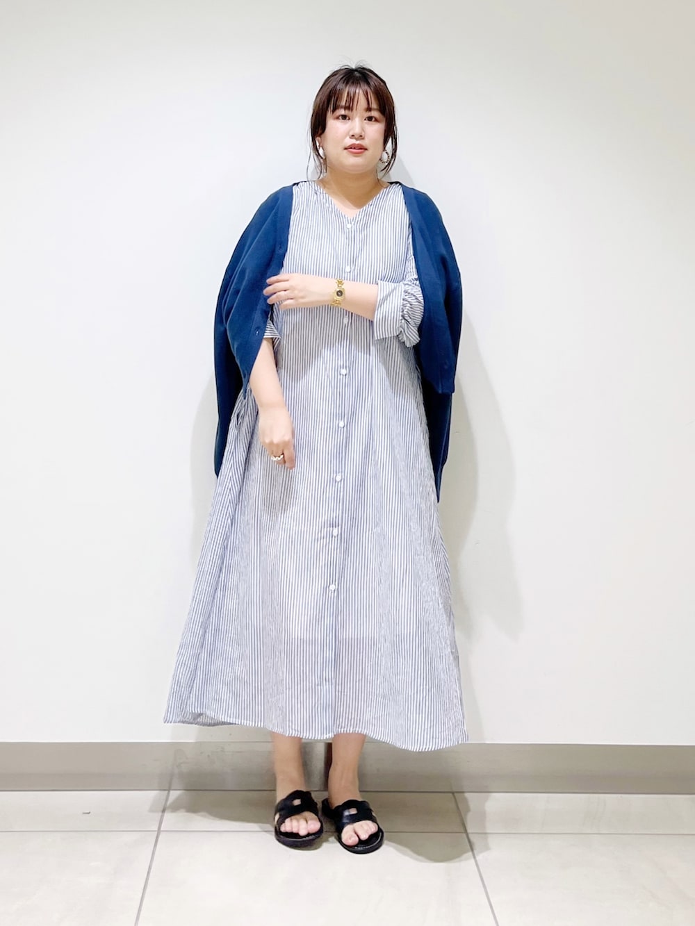 ブルー系のワンピース、ブルー系のニット/セーター、ブラック系のサンダルを着用したレディースの春コーディネートの3枚目の写真