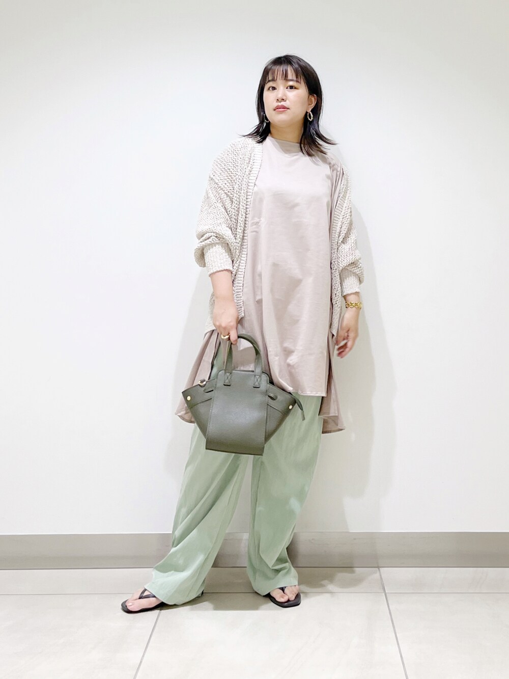 ホワイト系のカーディガン/ボレロ、ベージュ系のTシャツ/カットソー、グリーン系のハンドバッグを着用したレディースの夏コーディネートの4枚目の写真