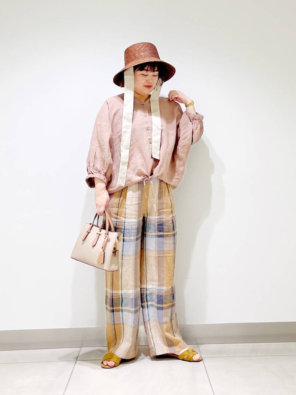 ベージュ系のハンドバッグ、イエロー系のその他パンツ、イエロー系のサンダルを着用したレディースの春コーディネートの7枚目の写真