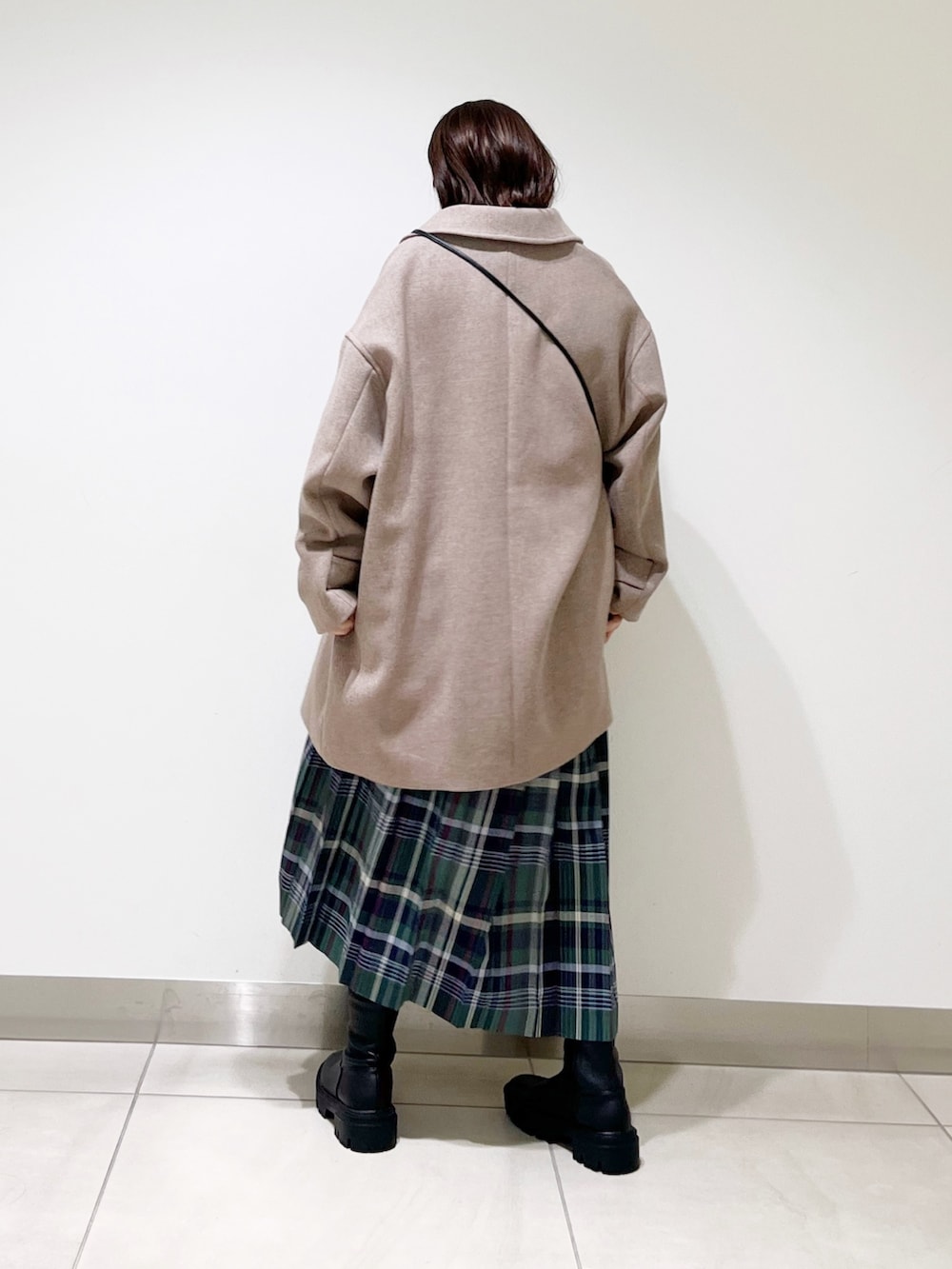 ブラウン系のその他アウター、ブラック系のニット/セーター、グリーン系のスカートを着用したレディースの秋コーディネートの5枚目の写真