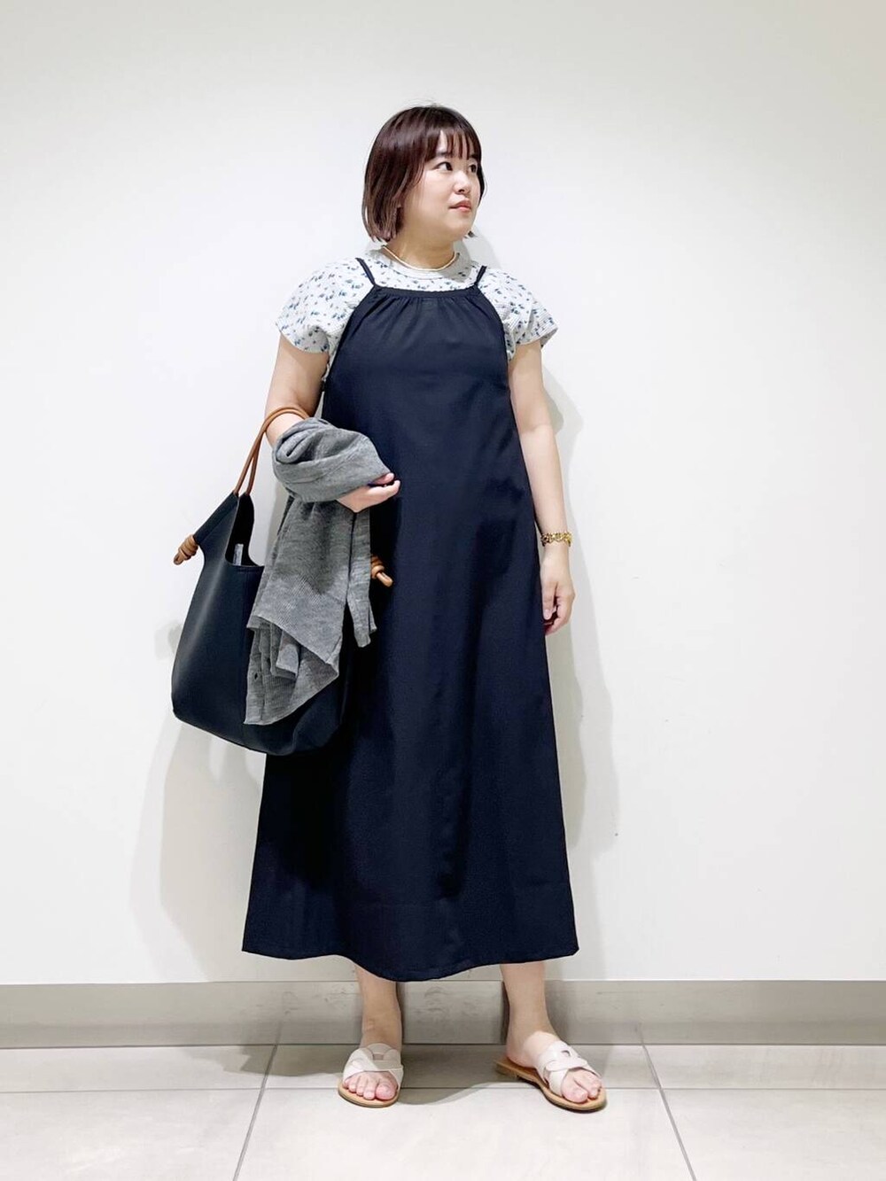 ブラック系のトートバッグ、グレー系のカーディガン/ボレロ、ホワイト系のサンダルを着用したレディースの春コーディネートの9枚目の写真