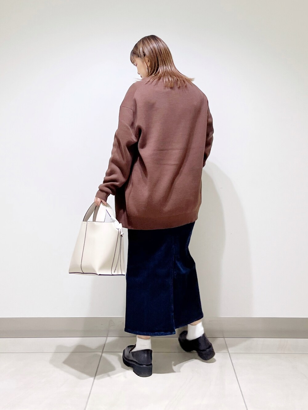 ブラウン系のカーディガン/ボレロ、グリーン系のTシャツ/カットソー、ホワイト系のトートバッグを着用したレディースの秋コーディネートの4枚目の写真