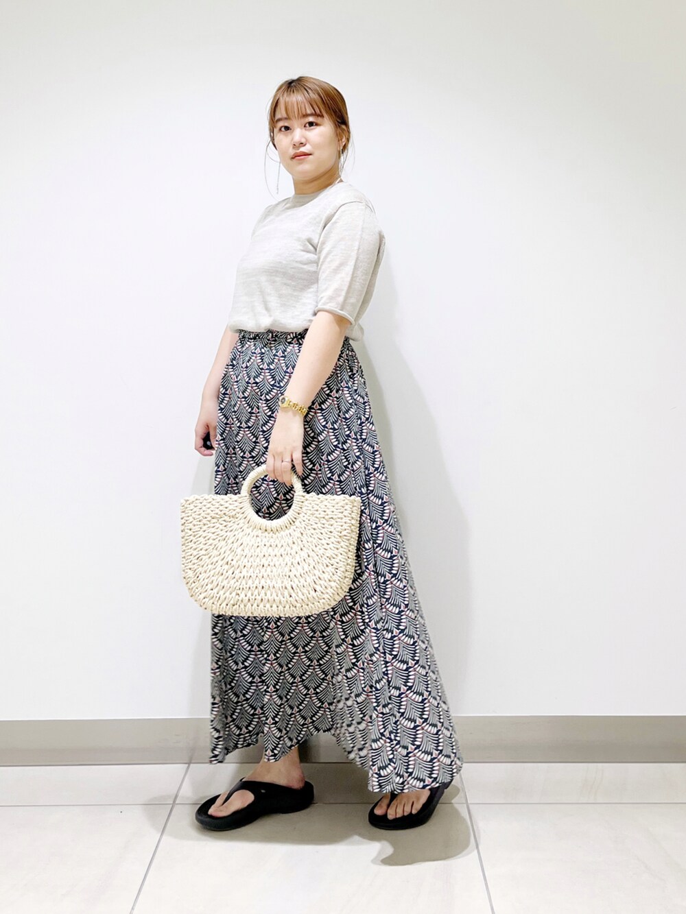 グリーン系のスカート、ベージュ系のTシャツ/カットソー、ホワイト系のハンドバッグを着用したレディースの春コーディネートの3枚目の写真