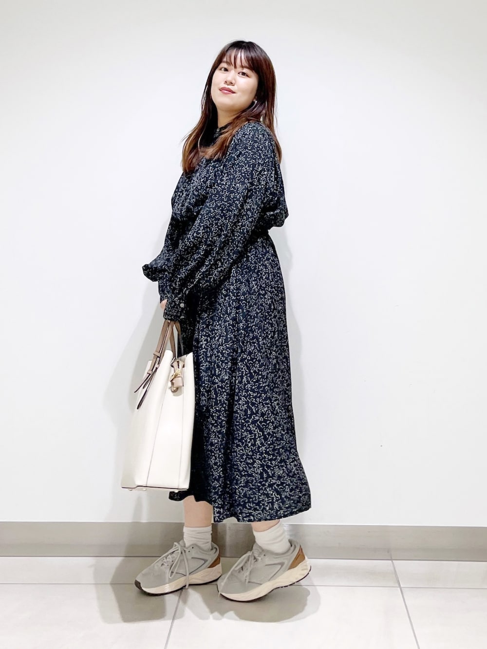 ブラック系のワンピース、ホワイト系のトートバッグ、グレー系のスニーカーを着用したレディースの夏コーディネートの7枚目の写真