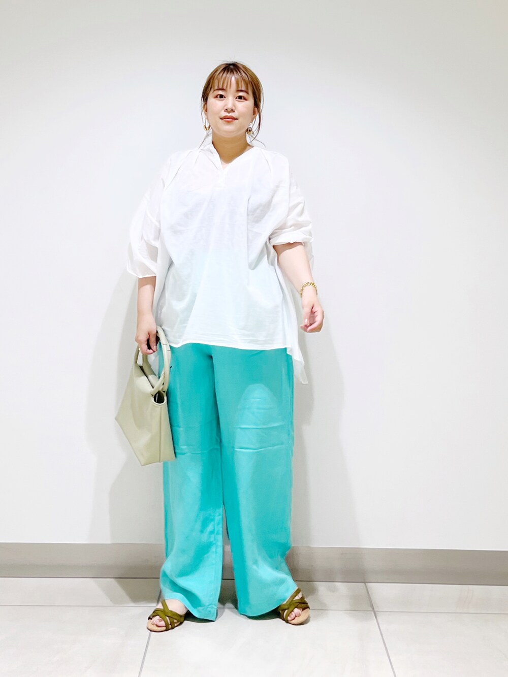 ホワイト系のシャツ/ブラウス、グリーン系のハンドバッグ、ブルー系のその他パンツを着用したレディースの夏コーディネートの2枚目の写真