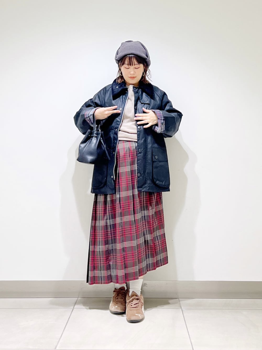 ブラック系のテーラードジャケット、グレー系のTシャツ/カットソー、ブラウン系のスカートを着用したレディースの秋コーディネートの3枚目の写真