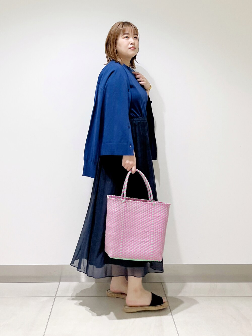 ブルー系のニット/セーター、ブルー系のカーディガン/ボレロ、ブルー系のスカートを着用したレディースの春コーディネートの4枚目の写真