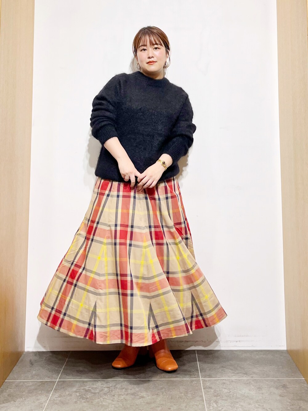 ブラック系のニット/セーター、ベージュ系のスカート、ピンク系のブーツを着用したレディースの秋コーディネートの3枚目の写真