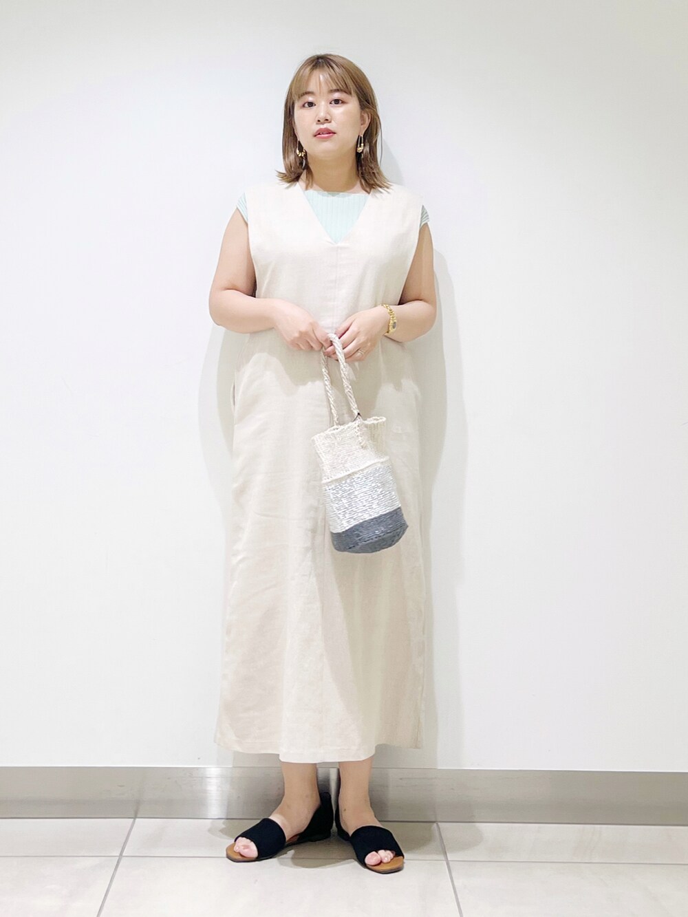 ベージュ系のワンピース、その他のハンドバッグ、ブラック系のサンダルを着用したレディースの夏コーディネートの2枚目の写真