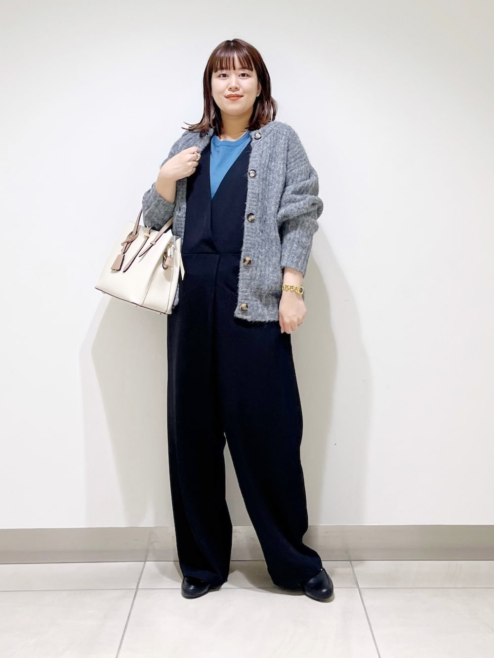 ブルー系のニット/セーター、グレー系のカーディガン/ボレロ、ブラック系のサロペット/オーバーオールを着用したレディースの秋コーディネートの8枚目の写真
