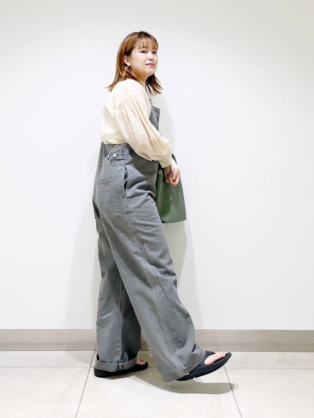グレー系のサロペット/オーバーオール、グリーン系のトートバッグ、ブラック系のサンダルを着用したレディースの夏コーディネートの5枚目の写真