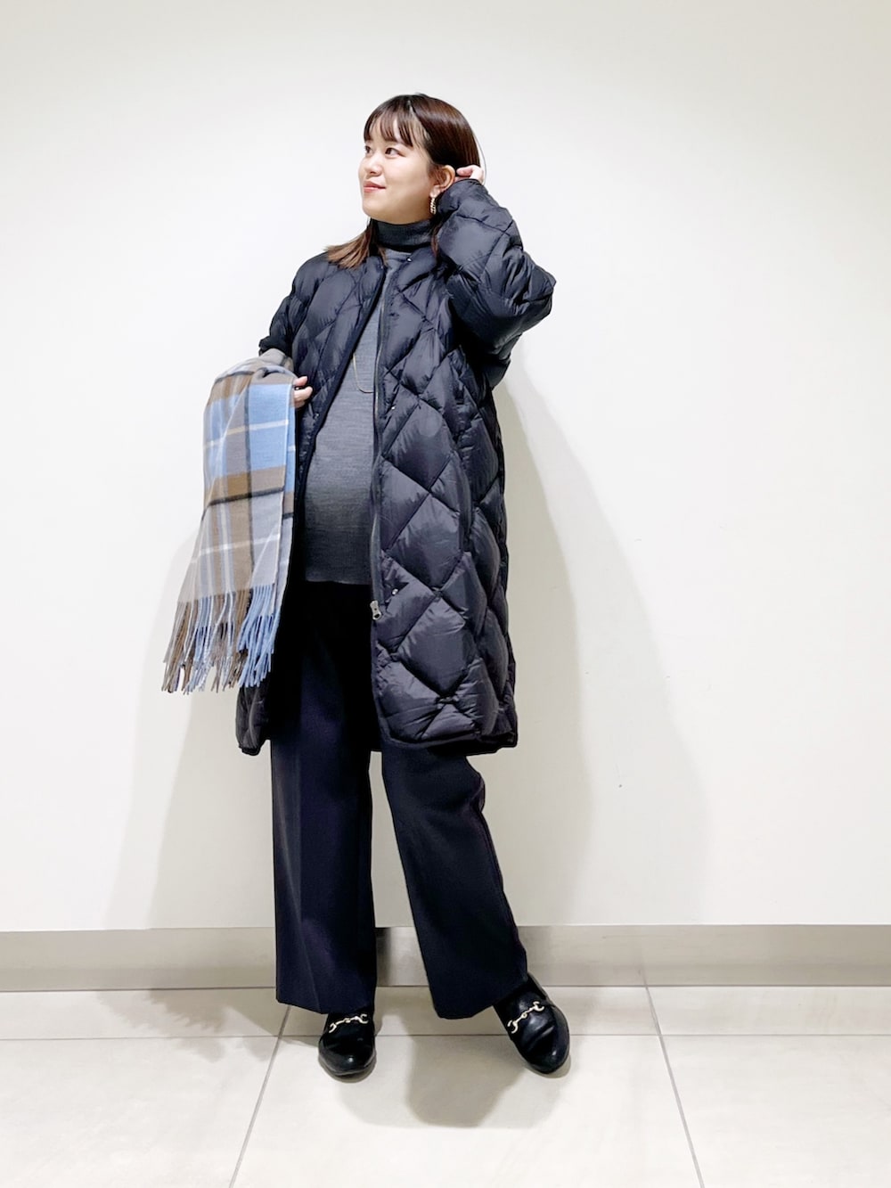 ブラック系のダウンジャケット/コート、グレー系のニット/セーター、グレー系のその他パンツを着用したレディースの冬コーディネートの6枚目の写真