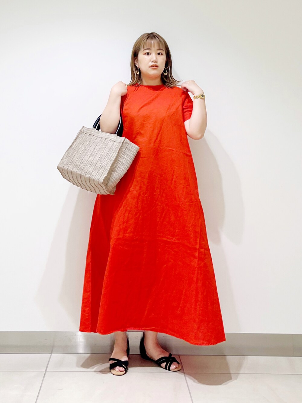 レッド系のワンピース、ベージュ系のトートバッグ、ブラック系のサンダルを着用したレディースの夏コーディネートの5枚目の写真