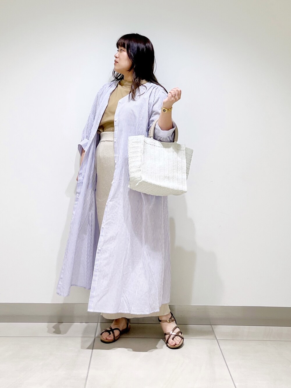 ベージュ系のTシャツ/カットソー、ベージュ系のスカート、パープル系のワンピースを着用したレディースの春コーディネートの10枚目の写真