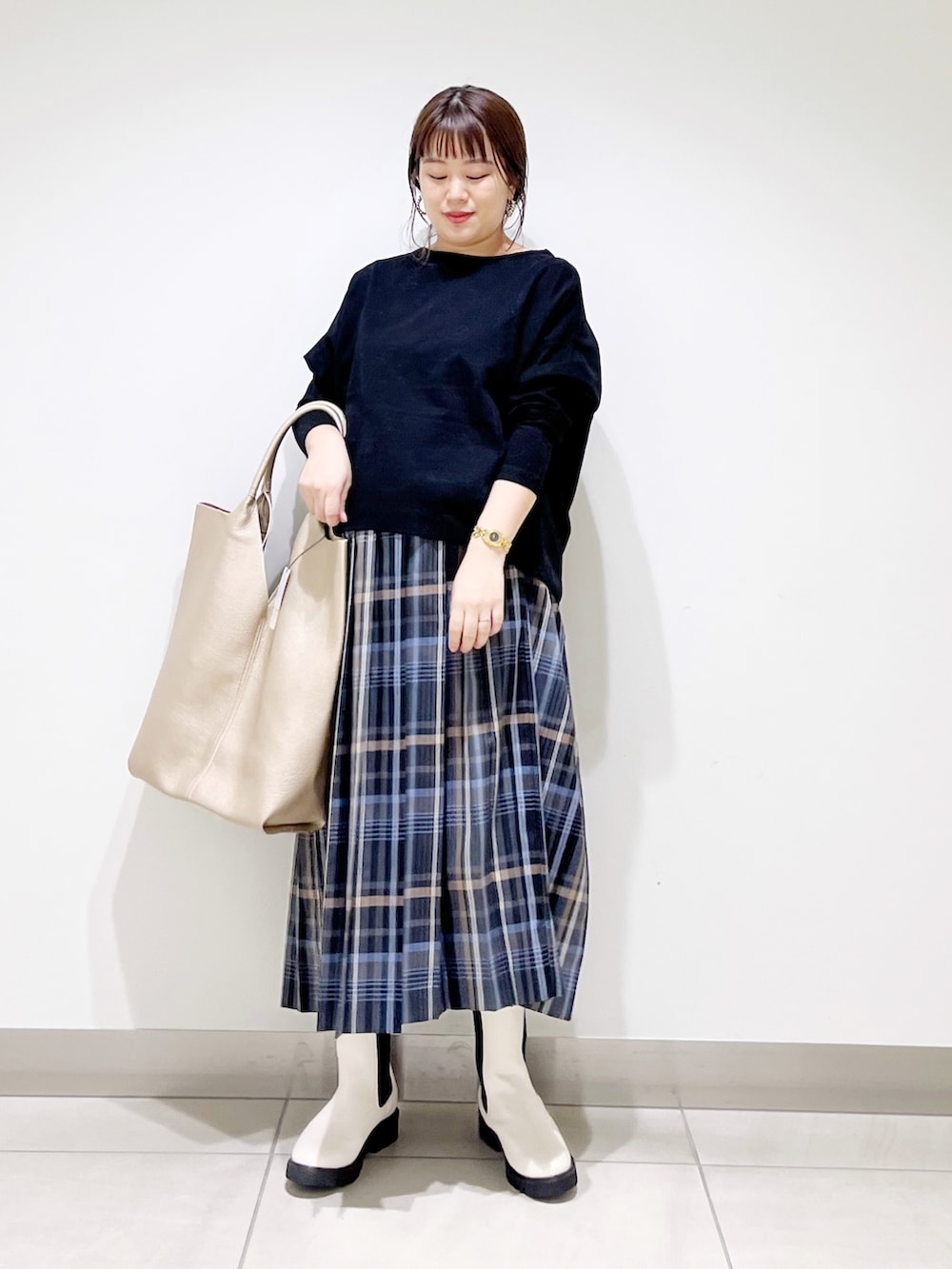 ブラック系のTシャツ/カットソー、ゴールド系のトートバッグ、ホワイト系のブーツを着用したレディースの秋コーディネートの10枚目の写真