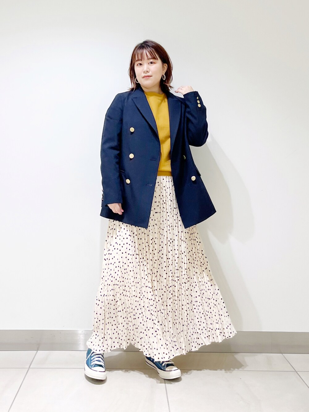 ブルー系のその他アウター、イエロー系のニット/セーター、ホワイト系のスカートを着用したレディースの冬コーディネートの5枚目の写真