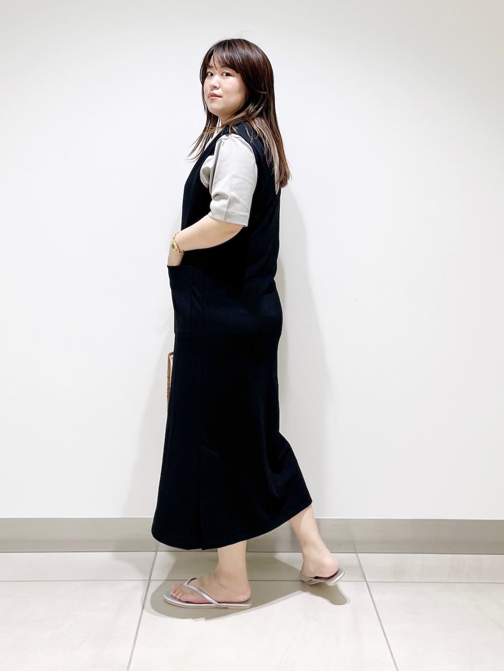 ブラック系のワンピース、グレー系のTシャツ/カットソー、ベージュ系のハンドバッグを着用したレディースの夏コーディネートの7枚目の写真