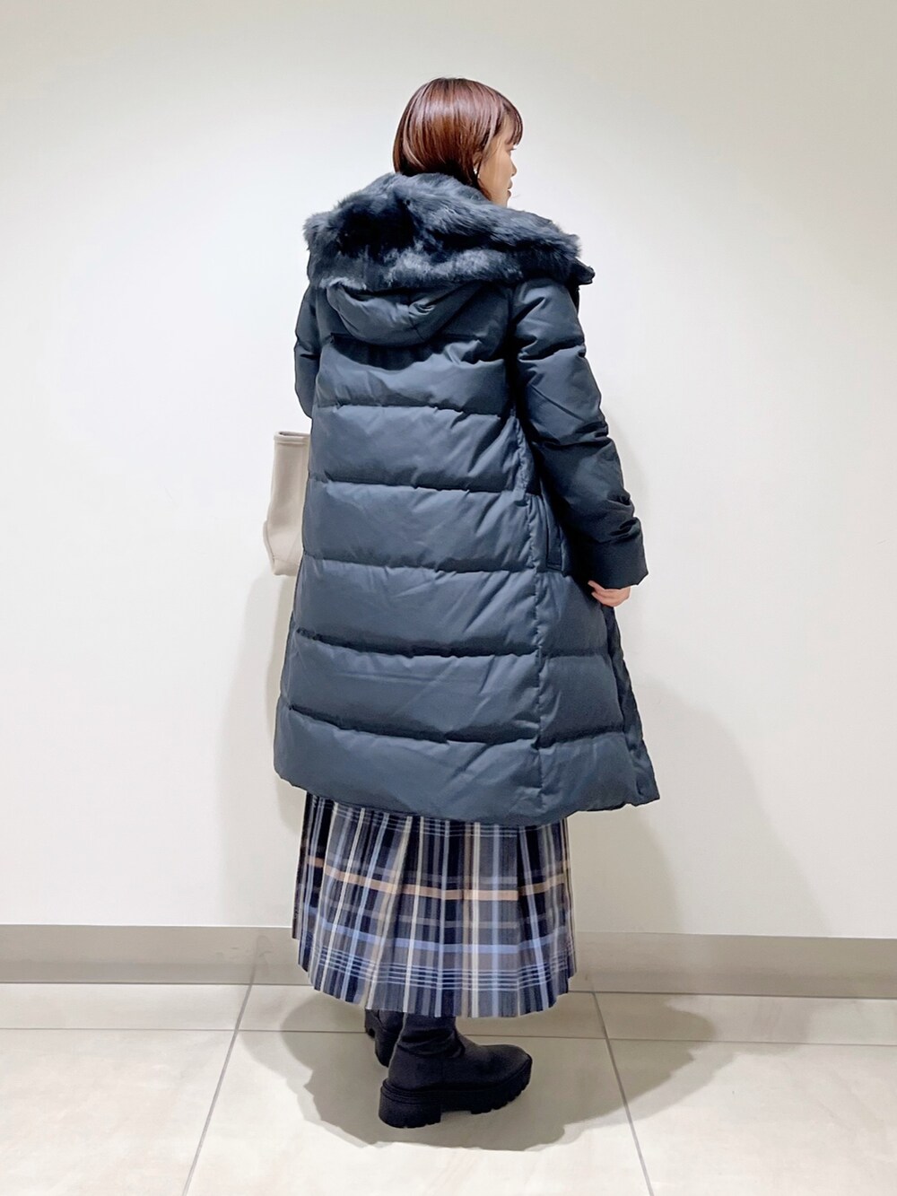 イエロー系のTシャツ/カットソー、ブラック系のダウンジャケット/コート、ブルー系のスカートを着用したレディースの秋コーディネートの4枚目の写真