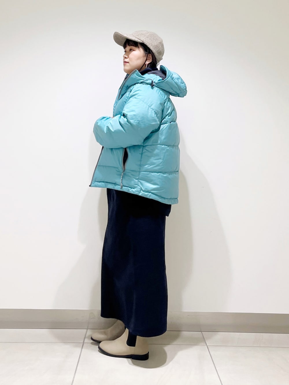 ブルー系のダウンジャケット/コート、ブルー系のTシャツ/カットソー、ブルー系のスカートを着用したレディースの冬コーディネートの3枚目の写真