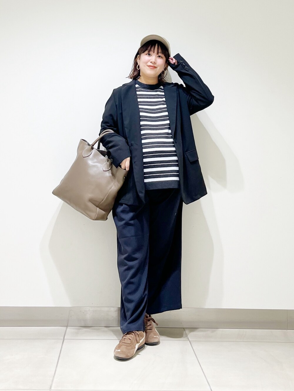 ブラック系のその他アウター、グレー系のニット/セーター、グレー系のトートバッグを着用したレディースの秋コーディネートの9枚目の写真