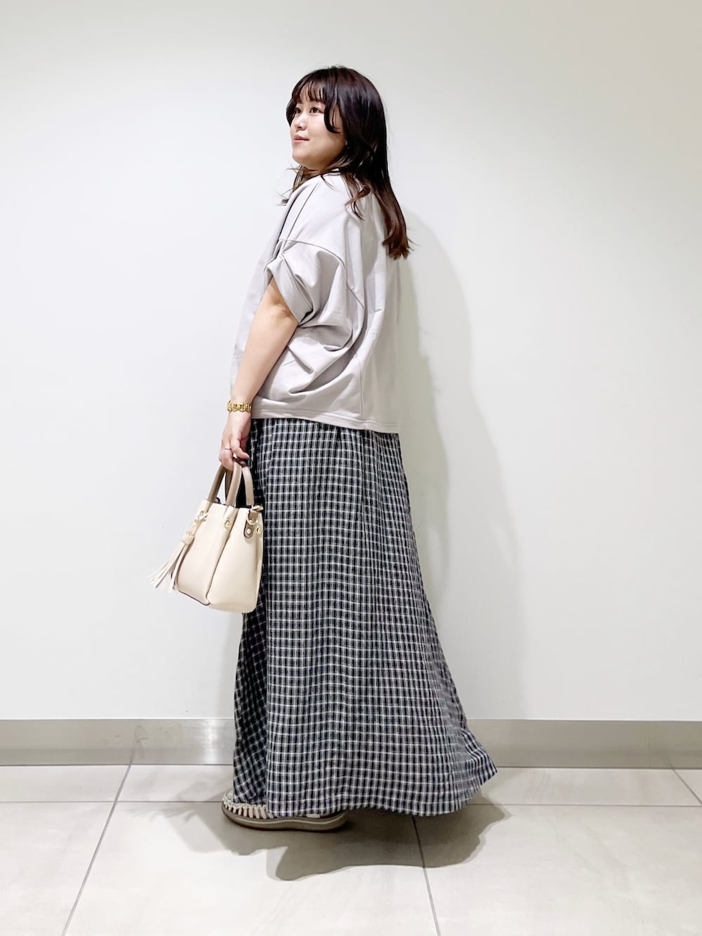 グレー系のTシャツ/カットソー、その他のスカート、ホワイト系のトートバッグを着用したレディースの春コーディネートの4枚目の写真