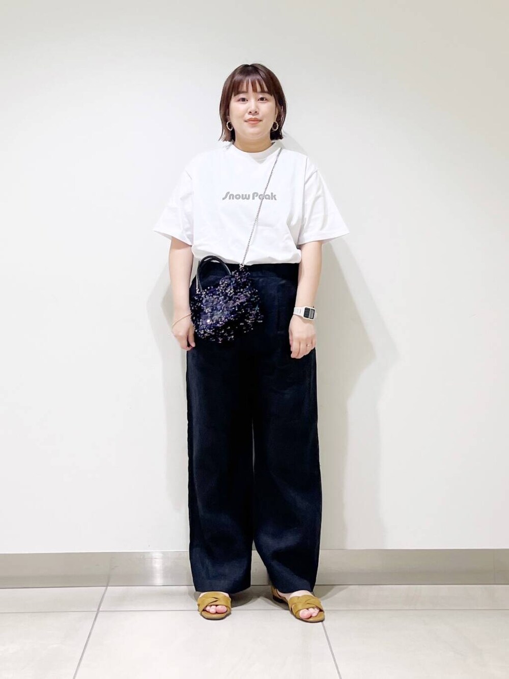 ブラック系のショルダーバッグ、ブラック系のその他パンツ、イエロー系のサンダルを着用したレディースの春コーディネートの6枚目の写真