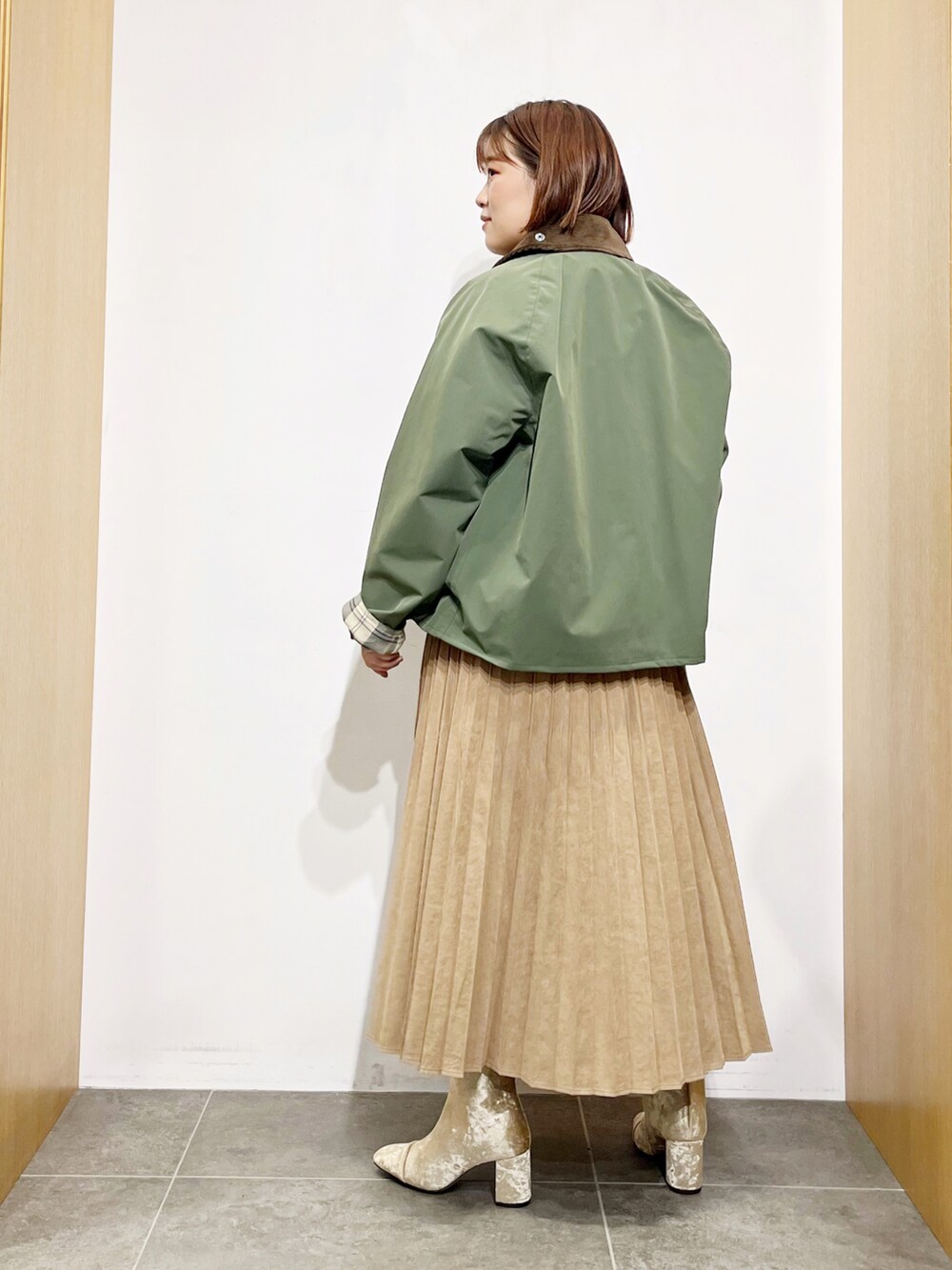 グリーン系のその他アウター、ホワイト系のニット/セーター、イエロー系のスカートを着用したレディースの秋コーディネートの4枚目の写真