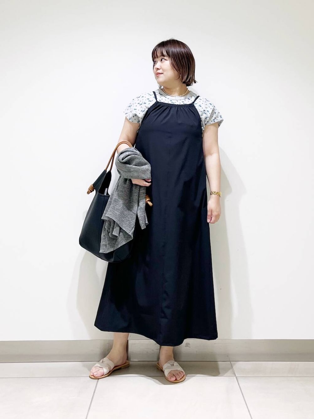 ブラック系のトートバッグ、グレー系のカーディガン/ボレロ、ホワイト系のサンダルを着用したレディースの春コーディネートの2枚目の写真