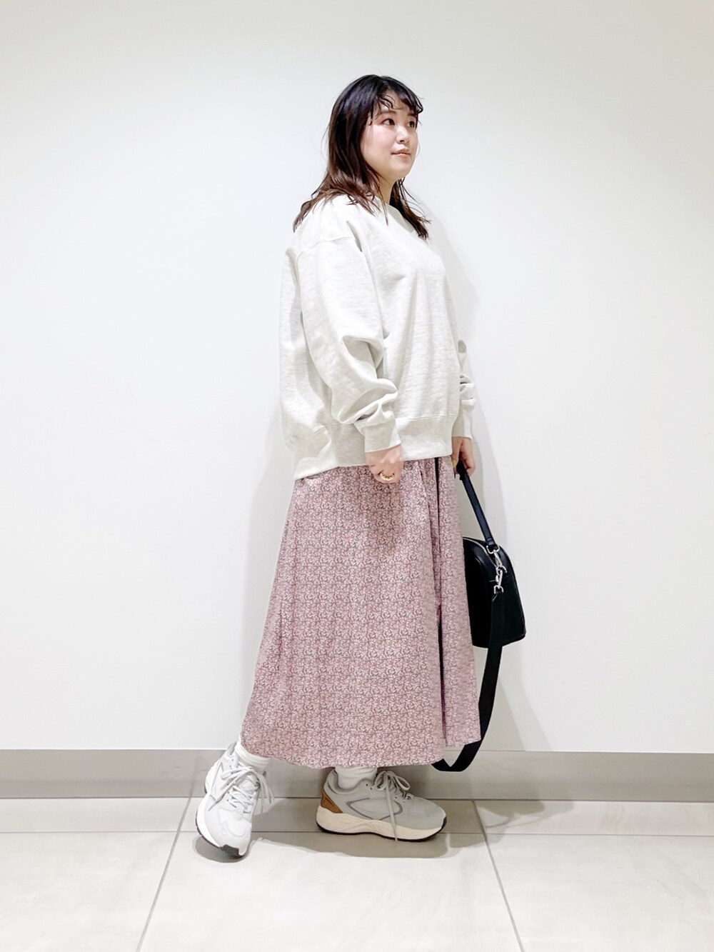 グレー系のスウェット、ピンク系のスカート、ブラック系のショルダーバッグを着用したレディースの春コーディネートの5枚目の写真