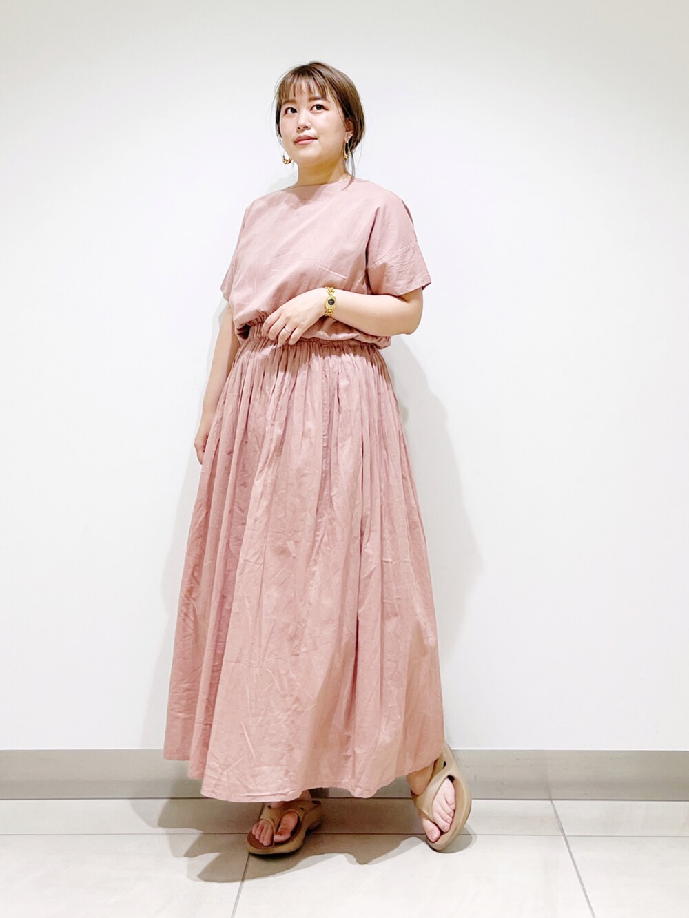 ピンク系のワンピース、ベージュ系のサンダルを着用したレディースの夏コーディネートの4枚目の写真