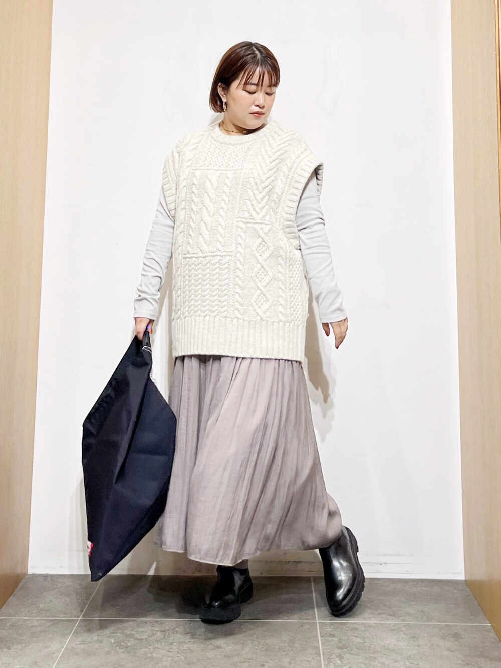 ホワイト系のニット/セーター、ブラック系のトートバッグ、グレー系のその他パンツを着用したレディースの秋コーディネートの2枚目の写真